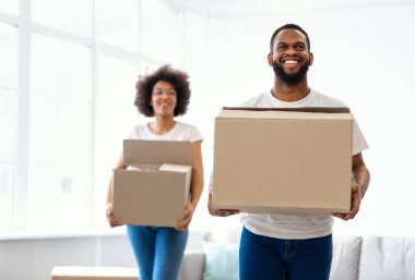 Karton kutuları taşıyan Afrikalı Amerikalı çift kendi evine giriyor.