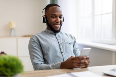 İş yerinde arıza yapan kulaklık takan Afrikalı adam.