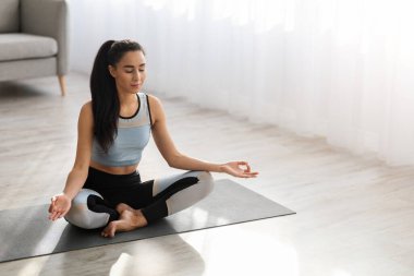 Kafkasyalı genç bir kadının evde meditasyon yaparken yüksek açılı görüntüsü