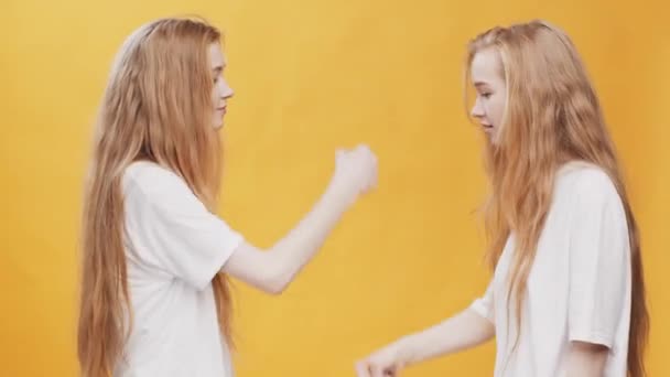 秘密握手致意。红头发的孪生姐妹互相望着对方，制造拳头碰撞和爆炸 — 图库视频影像