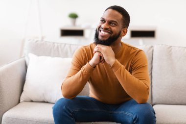 Mutlu Afrikalı Adam Evdeki koltukta otururken hayal kuruyor