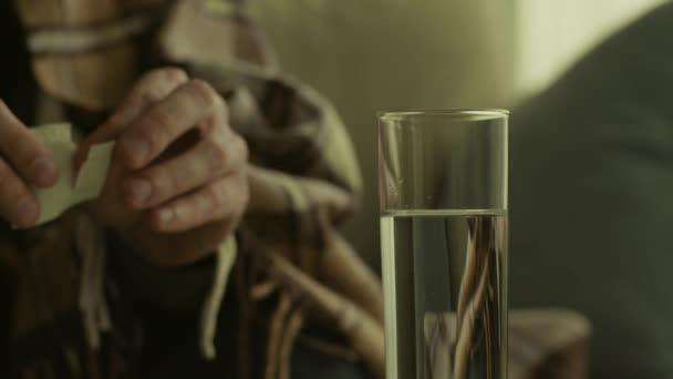 Close-up schot van zieke man gooien oplosbare pil in glas water, aspirine oplossen, slow motion — Stockvideo