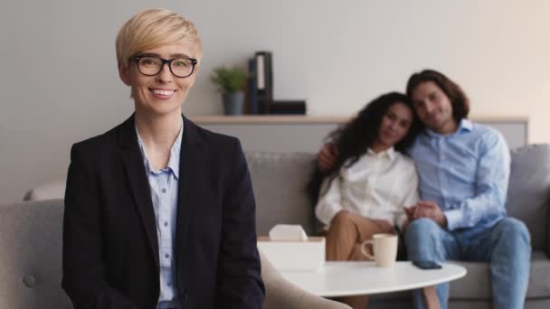 Professional woman psychologist smiling at camera, happy recouncilled couple cuddling after successful therapy on couch — Stock Video