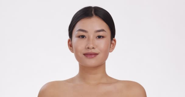 Joven mujer asiática sonriendo a la cámara, demostrando sus dientes blancos perfectos sanos, fondo blanco, cámara lenta — Vídeos de Stock