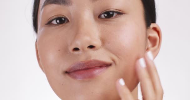 Masaje lifting facial. Joven mujer asiática masajeando su cara para el efecto de drenaje linfático, fondo blanco estudio — Vídeo de stock