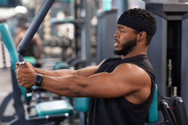 Göğüs güvertesi makinesinde çalışan vücut geliştiricinin yan görünümü