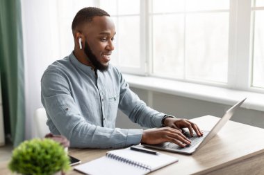 Modern Ofiste Kulaklık takan Siyah İşadamı Dizüstü bilgisayarda çalışıyor
