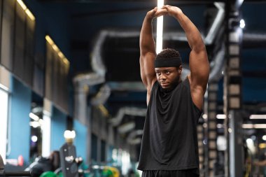 Kas yığını Afrikalı Amerikalı vücut geliştirici spor salonunda çalışıyor.