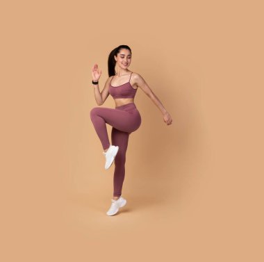 Pembe Arkaplanda Yüksek Dizler Egzersizi Yapan Sporcu Kadın