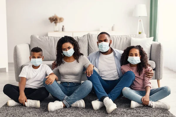 Black family in medical masks during home quarantine