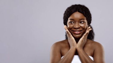 Havluya sarılı şirin Afrikalı kadın portresi Heyecandan yana bakıyor