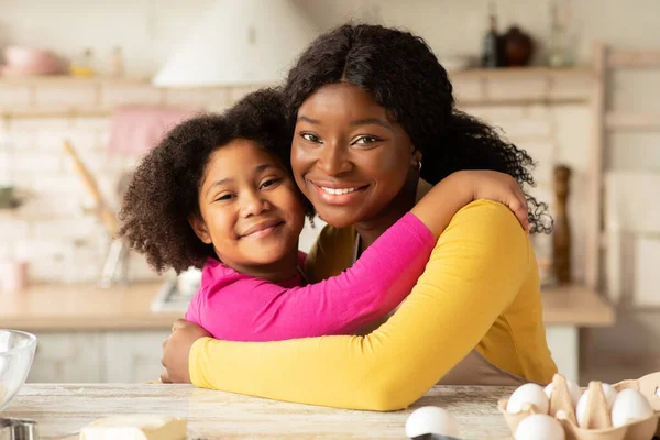Pojęcie Dnia Matki. Portret czarnej mamy i córki Obejmujących w kuchni — Zdjęcie stockowe