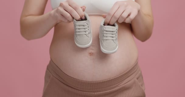 Esperando un milagro. Primer plano de gran vientre embarazada y botas diminutas, mujer pisando con zapatos — Vídeo de stock