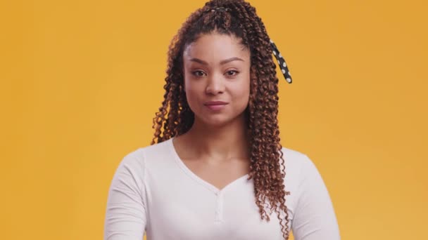 Tyst, håll tyst. Mystisk afrikansk amerikansk dam sätta fingret på läppar, visar hysch tecken, orange studio bakgrund — Stockvideo