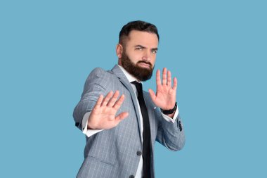 Kendine güveni tam bir ofis çalışanı. Mavi stüdyo arka planında olumsuz bir tavır sergiliyor.