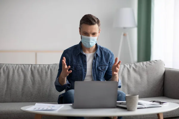 Businessman in face mask having online conference from home