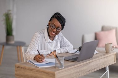 Webinar 'a katılan neşeli iş kadını evde dizüstü bilgisayar kullanıyor.