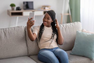 Akıllı telefondan selfie çeken sevimli siyahi bayan.