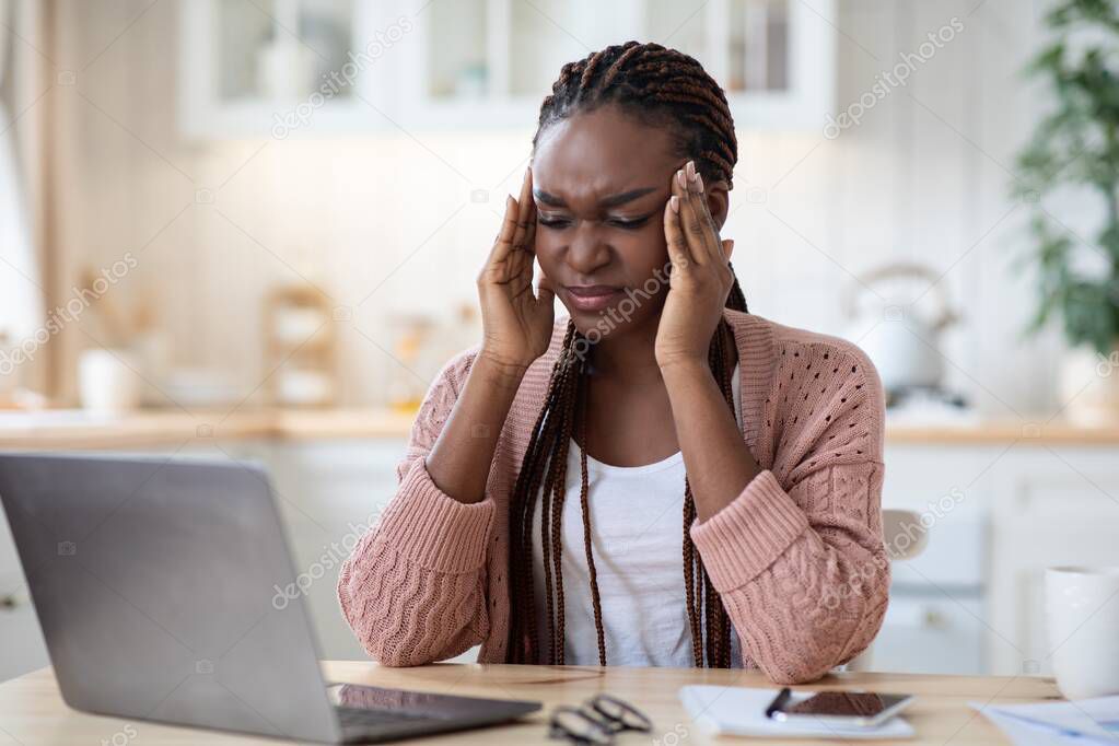 Stressed African Woman Suffering From Headache While Working On Laptop At Home