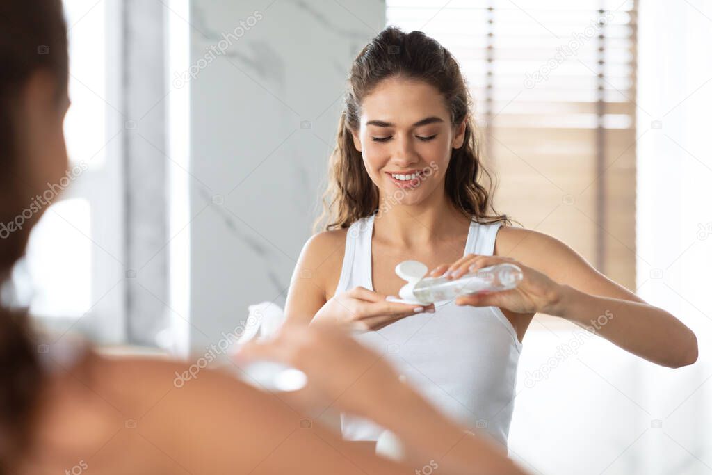 Happy Woman Doing Facial Skincare Routine Cleansing Face In Bathroom