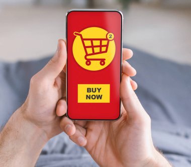 Alışveriş uygulaması ile akıllı telefonu tutan erkeklerin yakın çekimi