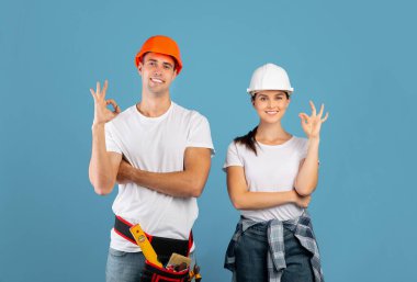 Profesyonel Tamir Servisi. Sert şapkalı Gülümseyen Adam ve Kadın İyi Hareketler Gösteriyor