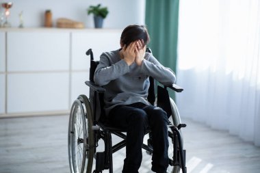 Engelli gençlerde depresyon. Tekerlekli sandalyedeki mutsuz ergen evde yalnızlıktan ağlıyor.