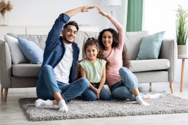 Aile koruması. Anne ve baba, kızlarının üstünde el sallıyorlar.