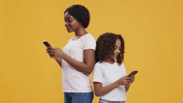 아프리카 계 미국인 어머니와 딸들 이 스마트폰으로 인터넷을 하고 있습니다. — 비디오