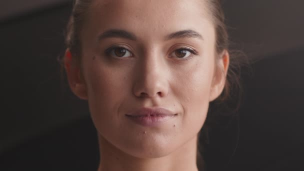 Portret van een jonge rustige vrouw die naar de camera kijkt en knippert, slow motion — Stockvideo