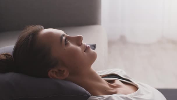 Pratique de relaxation. Gros plan femme méditant à la maison, penchée sur le canapé avec les yeux fermés, ralenti — Video