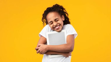 Teknoloji aşığı. Heyecanlı siyah kız kişisel bilgisayarına sarılıyor