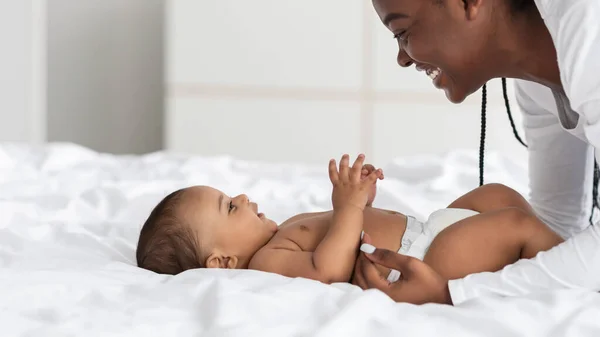 Afro americano mãe jogar no cama com ela bonito infantil — Fotografia de Stock