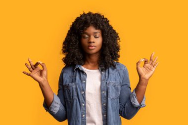 Zenci kadın gözlerini kapar ve zen jestinde ellerini kaldırır.