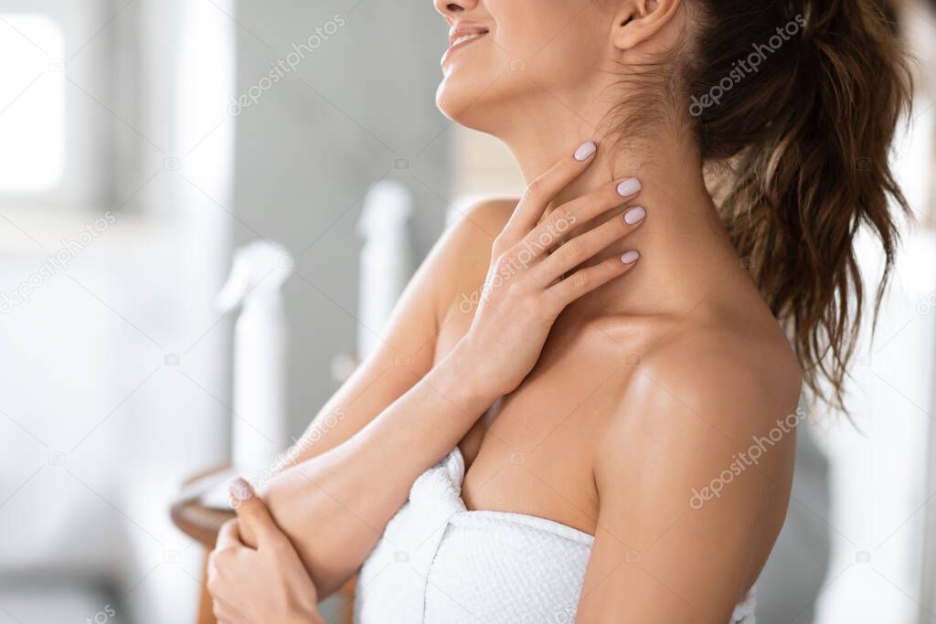 Woman Touching Neck Moisturizing Skin After Shower Standing In Bathroom