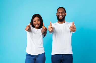 Mutlu siyah çift başparmak işareti yapıyor ve gülümsüyor.