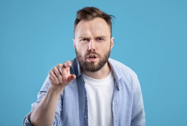 Senin hatandı. Öfkeli Kafkasyalı adam, mavi stüdyo geçmişini suçlayarak ekranı işaret ediyor.