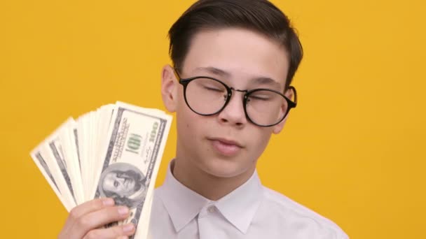 Rich adolescente menino segurando dinheiro sobre fundo amarelo — Vídeo de Stock