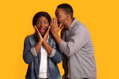 Sırrı paylaşmak. Zenci adam heyecanlı kız arkadaşıyla dedikodu yapıyor.