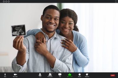 Bebek ultrasonu gösteren mutlu siyah çiftin pov ekranı.