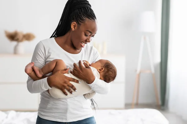 Madre afroamericana cantando una canción de cuna para que el bebé duerma —  Fotos de Stock