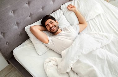 Mutlu uyuyan Arap adam, sabah uyandığında iyi uykudan uyanır.