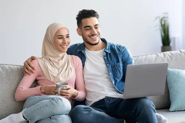 Relaxed arab family watching movie on laptop