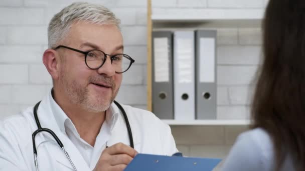 Doctor hablando con enferma paciente dama teniendo cita en la clínica — Vídeo de stock