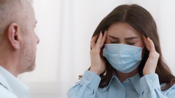 Pacientka trpící bolestí hlavy stěžující si lékařka na klinice — Stock video