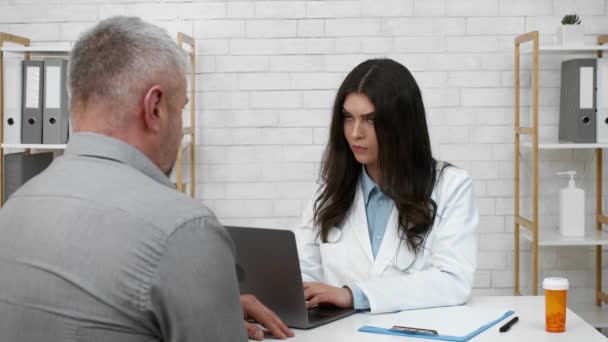 Älterer männlicher Patient beschwert sich bei Arzt über Symptome in Klinik — Stockvideo