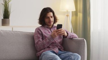 Adam evde dinleniyor, akıllı telefondan arkadaşlarıyla sohbet ediyor, sosyal medyada geziniyor veya iletişim kuruyor.