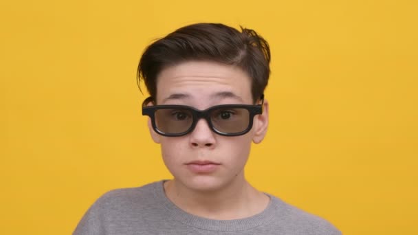 Emocionado adolescente con gafas 3D comiendo palomitas de maíz, fondo amarillo — Vídeos de Stock