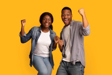 Şanslı kazananlar. Coşkulu genç siyah adam ve kadın Heyecanla Yumruklarını kaldırıyor