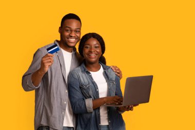 Online Shopping Concept. Happy african american couple with laptop and credit card